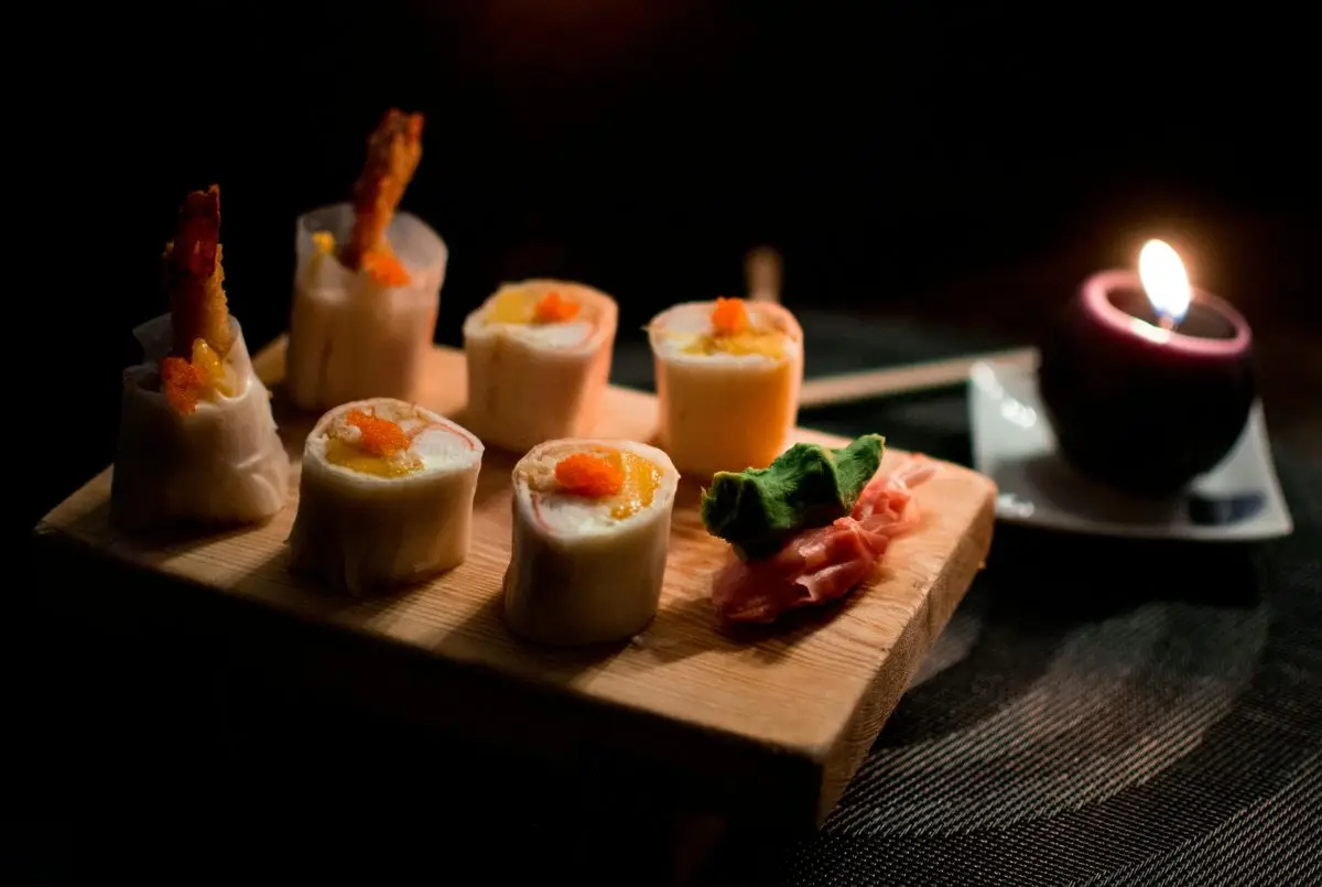 pexels-photo-3628428-3628428 Elegant sushi presentation with sushi rolls, garnishes, and candlelight.
