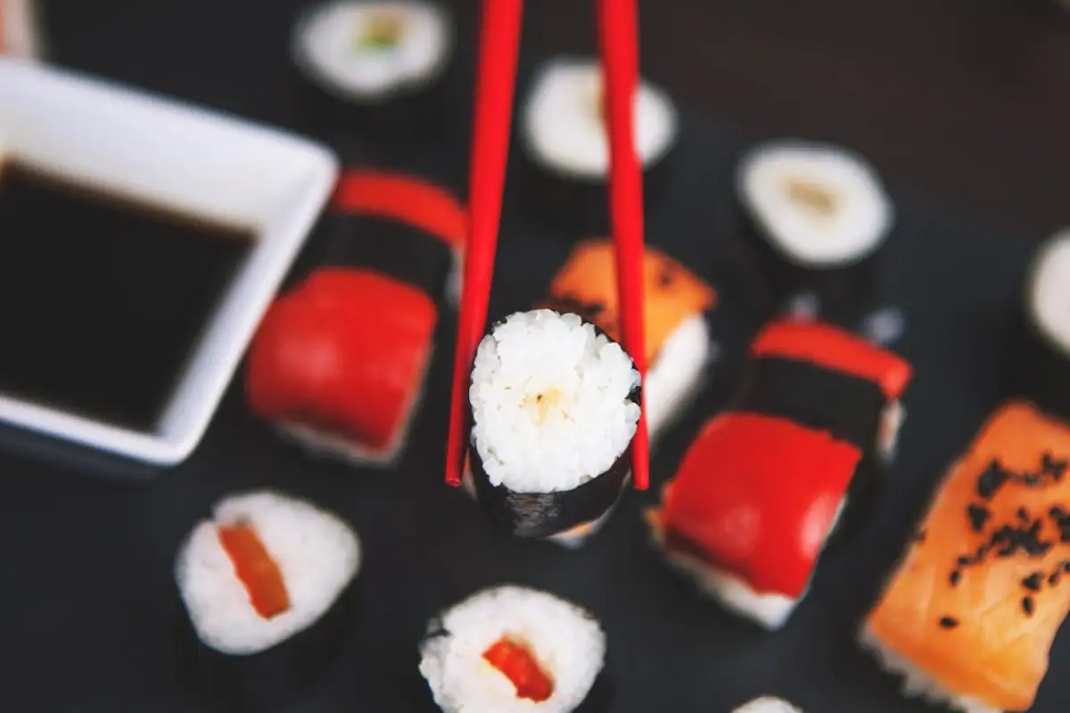 pexels-photo-539430 A selection of various sushi rolls with chopsticks on a dark plate, featuring vivid colors and fresh ingredients.